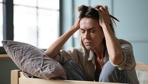 Женщина держится за свои волосы